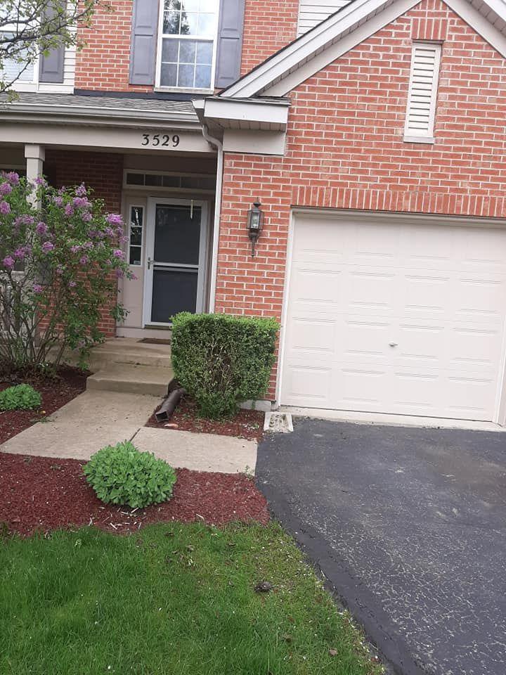 Mulched beds and trimmed shrubs at the front of a Rockford, IL home