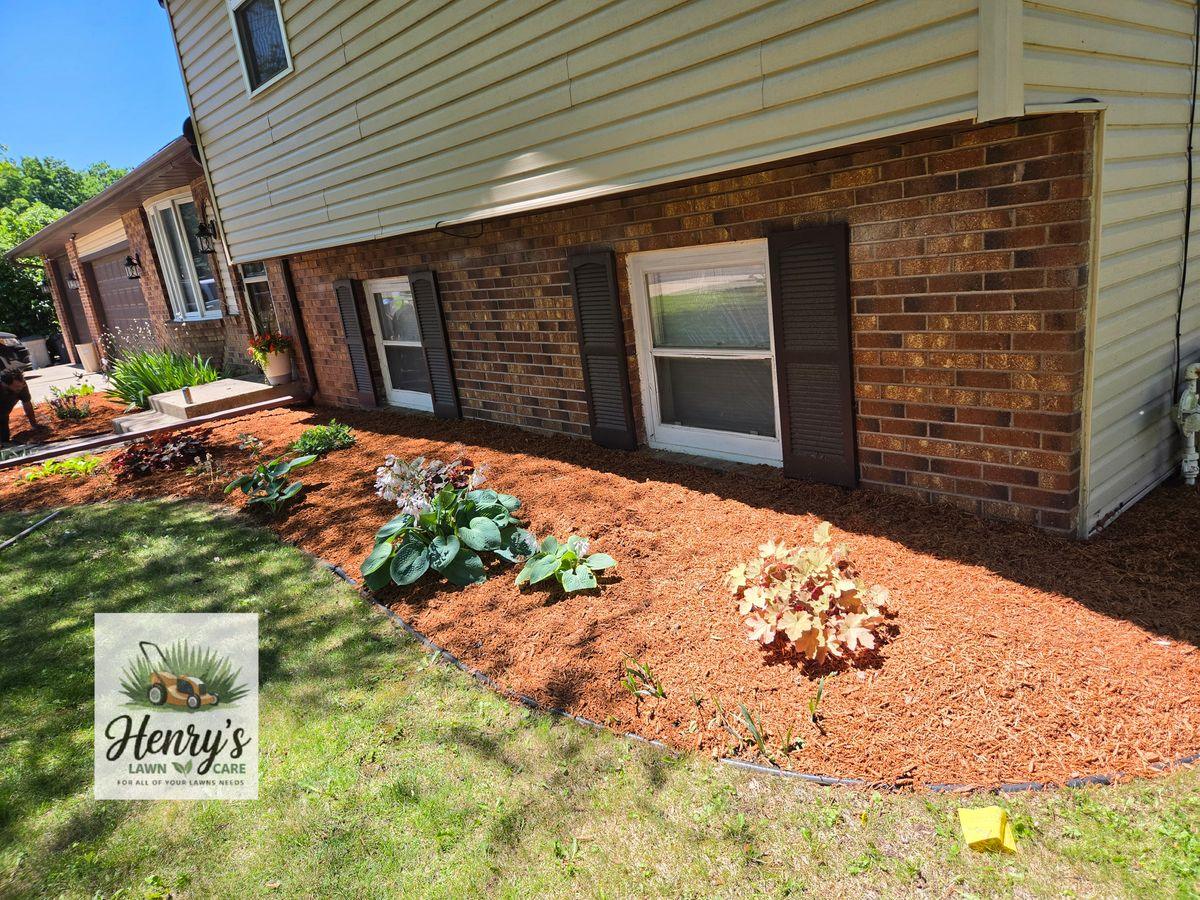 New mulch and plants in a bed against a brick home in Rockford, IL